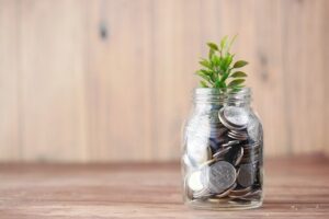 jar of coins with a plant growing