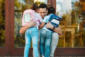 Father hugging children - successful coparenting