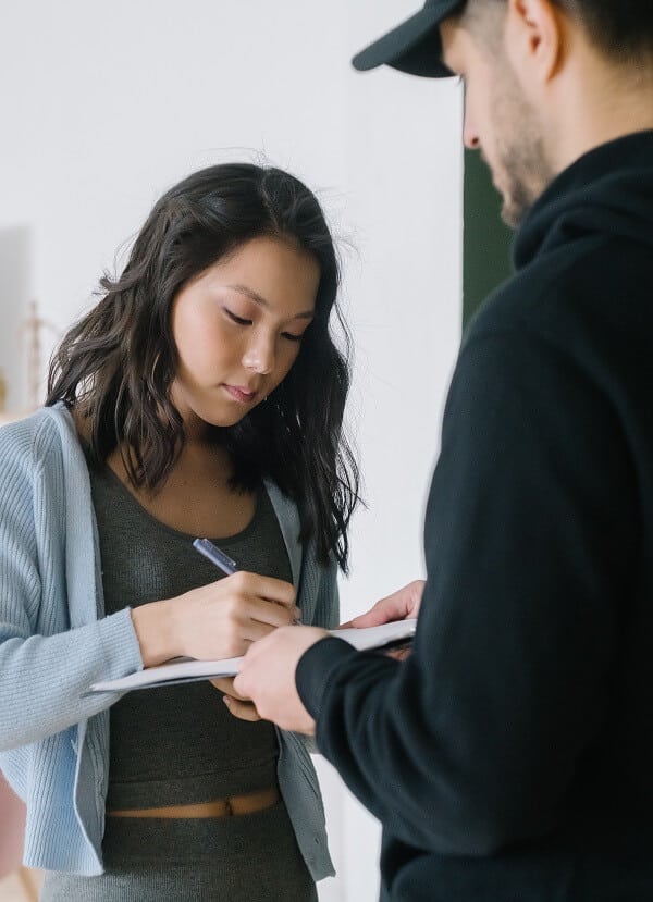 Woman signing for service of divorce application papers in one sided divorce